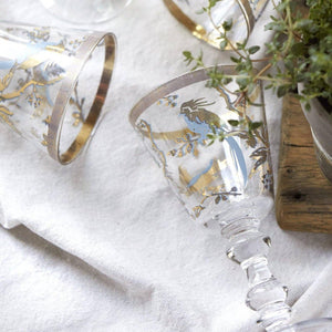 Decorative wine glasses with gold and blue bird designs.