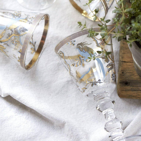 Decorative wine glasses with gold and blue bird designs.